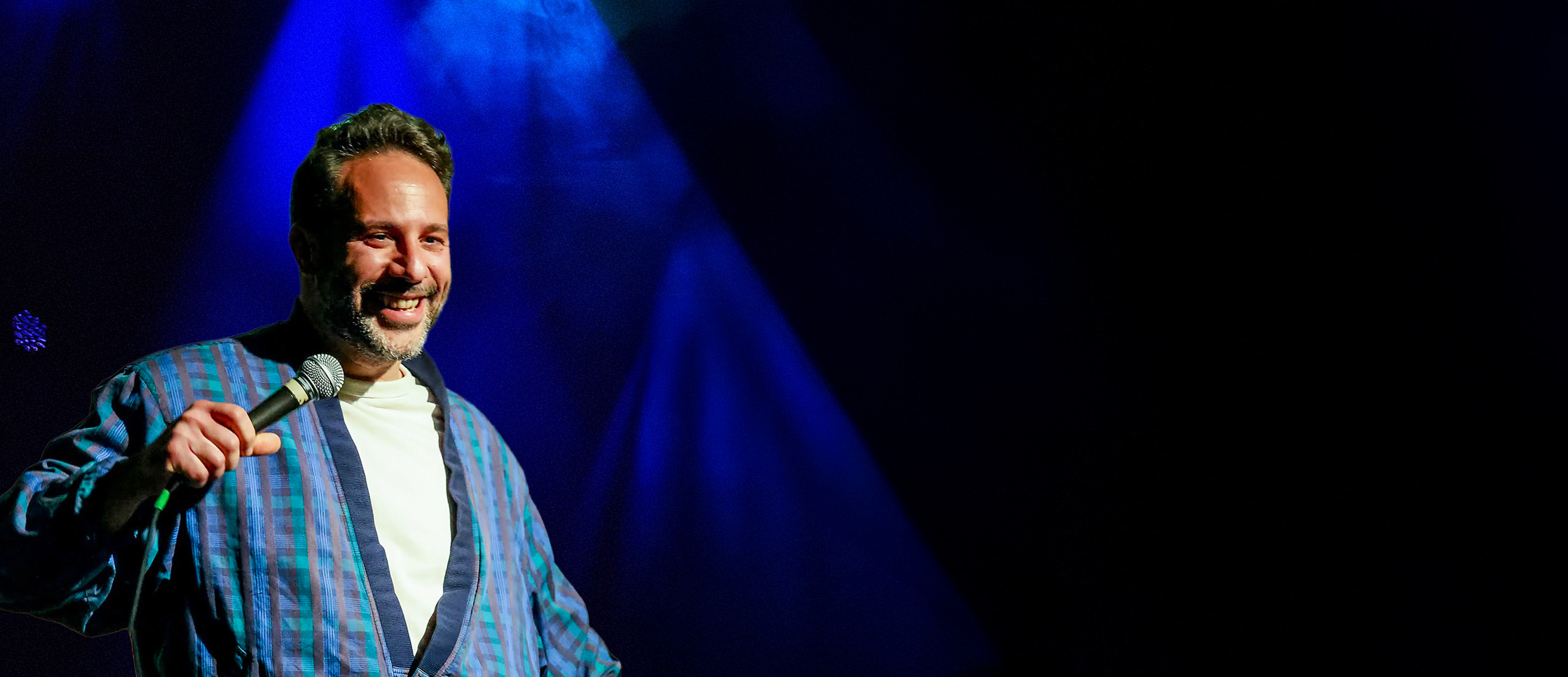 Maurizio Morina sur scène, micro à la main, pour son spectacle OUSKONVA ?